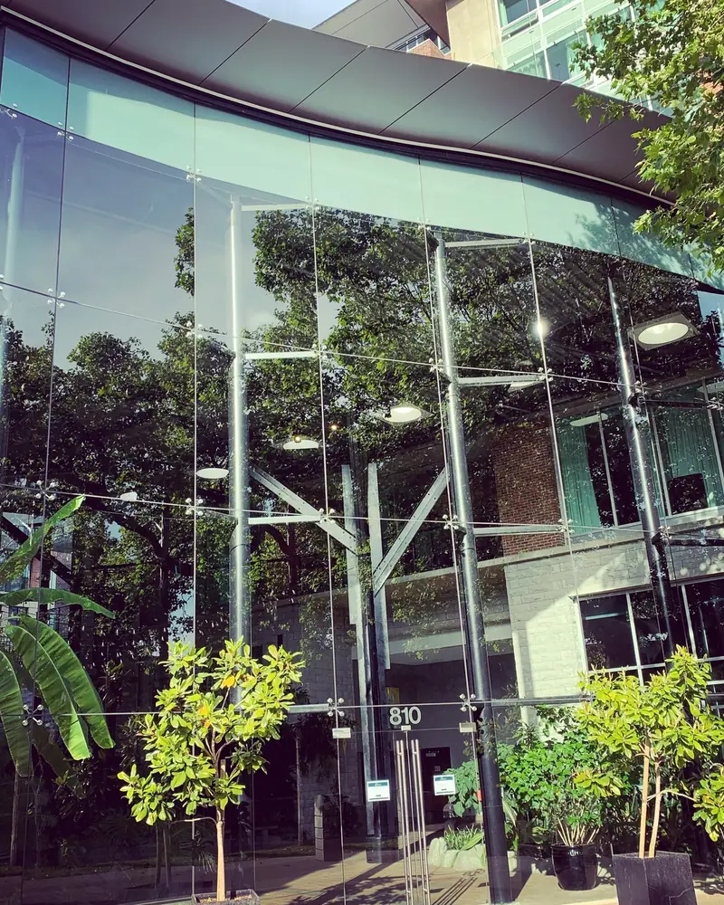 The curved glass facade of 810 Humboldt Street, with the street number on the glass