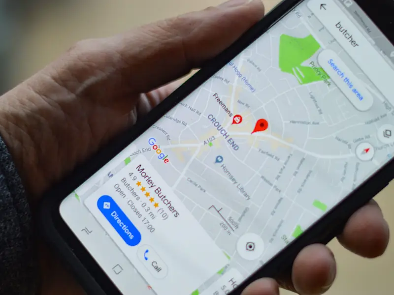 A phone showing a business pinned on Google Maps